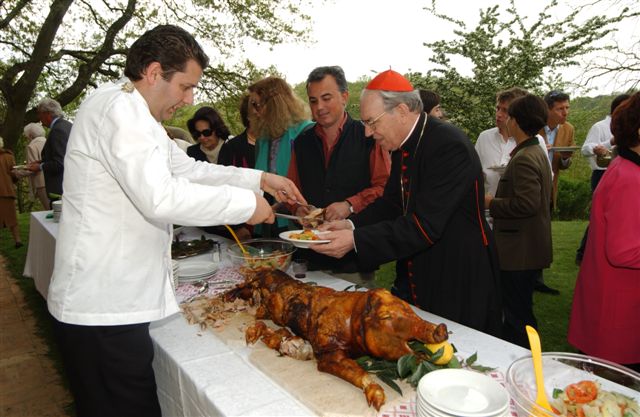 Il cardinale Giovanni Battista Re a Campagnano alle prese con la porchetta